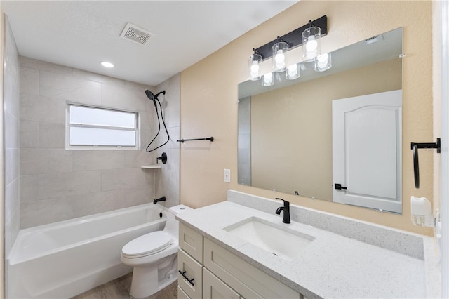 full bathroom featuring tiled shower / bath combo, vanity, and toilet