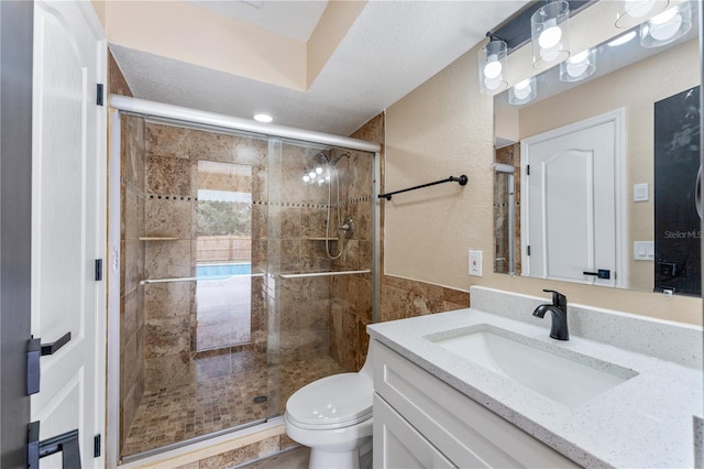 bathroom with vanity, toilet, and a shower with door