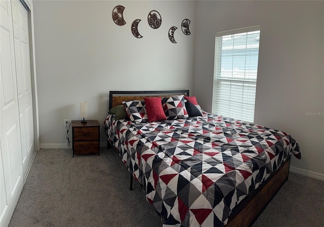 carpeted bedroom with a closet and baseboards