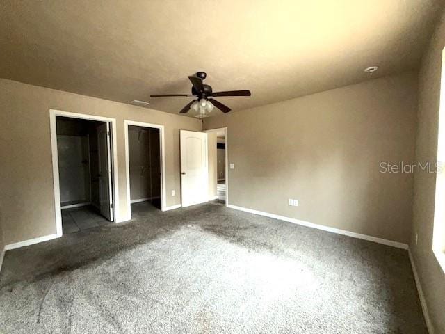 unfurnished bedroom featuring ceiling fan, a walk in closet, ensuite bath, and a closet