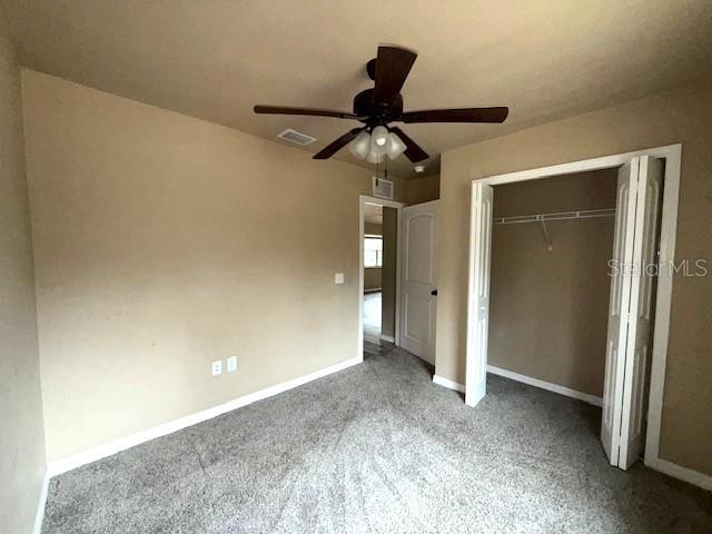 unfurnished bedroom featuring a closet, ceiling fan, and carpet