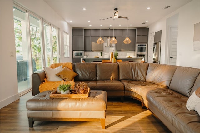 living room with ceiling fan and light wood-type flooring