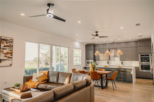 living room featuring ceiling fan and light wood-type flooring