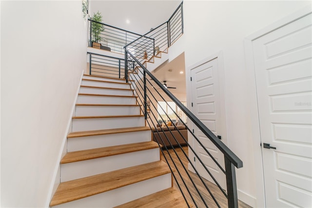 stairs featuring a high ceiling and hardwood / wood-style floors