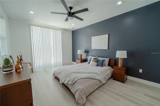 bedroom featuring ceiling fan, multiple windows, and light wood-type flooring