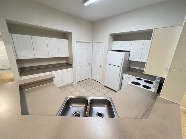 kitchen featuring white cabinetry, sink, white fridge, and light tile patterned floors