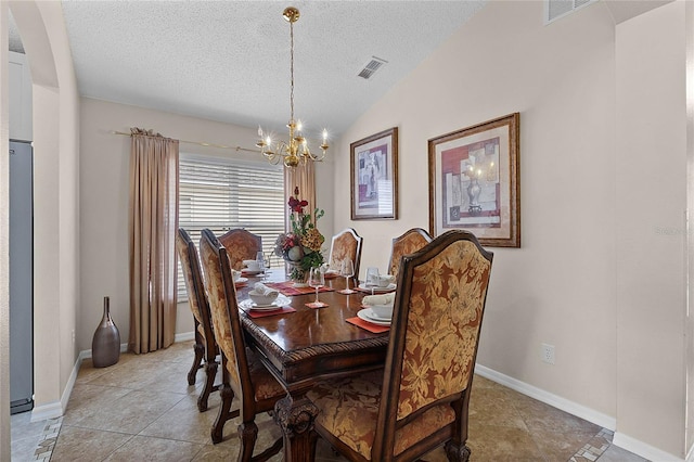 tiled dining area featuring lofted ceiling, a textured ceiling, and a chandelier