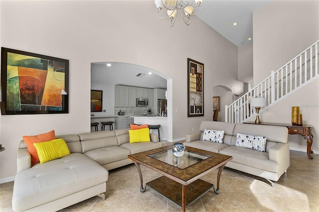 tiled living room featuring high vaulted ceiling and a notable chandelier