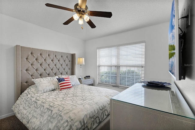 carpeted bedroom with ceiling fan and a textured ceiling