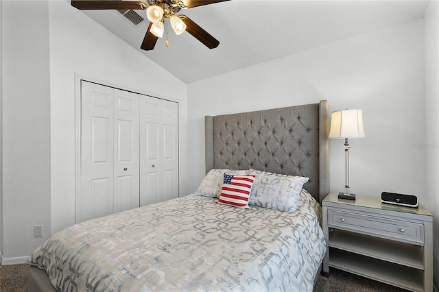 bedroom with dark colored carpet, vaulted ceiling, ceiling fan, and a closet