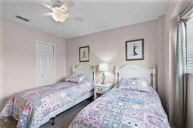 bedroom featuring ceiling fan, carpet, a closet, and a textured ceiling