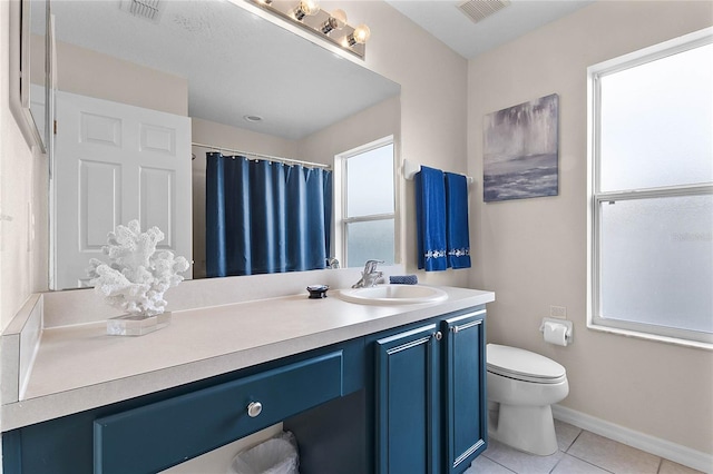 bathroom with tile patterned flooring, vanity, and toilet