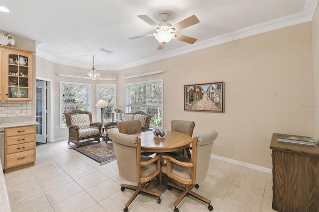 tiled dining area with crown molding and ceiling fan with notable chandelier