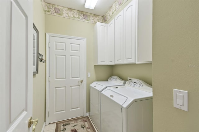 washroom featuring light tile patterned flooring, cabinets, and washer and dryer