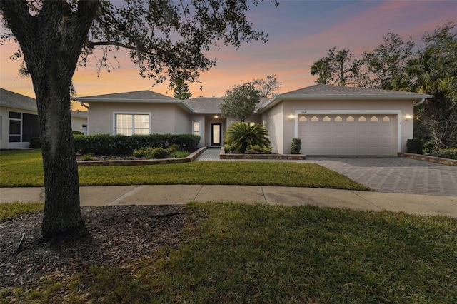 view of front of house with a garage and a lawn