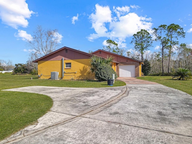 view of side of home featuring a garage, a yard, and central air condition unit