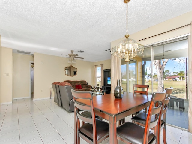 dining room featuring light tile patterned floors, ceiling fan with notable chandelier, and a textured ceiling