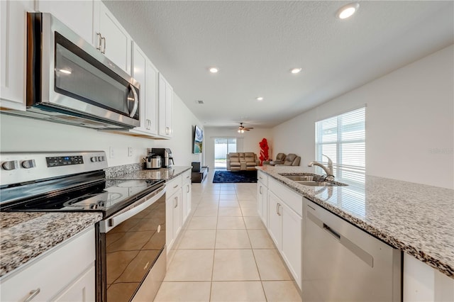 2265 Tay Wes Dr, Saint Cloud, FL 34771 - kitchen featuring stainless steel appliances, light stone countertops, sink, and white cabinets