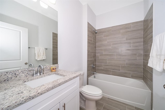 full bathroom with tiled shower / bath, vanity, and toilet