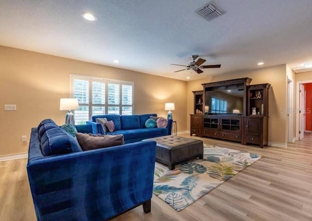living room featuring ceiling fan and light hardwood / wood-style flooring