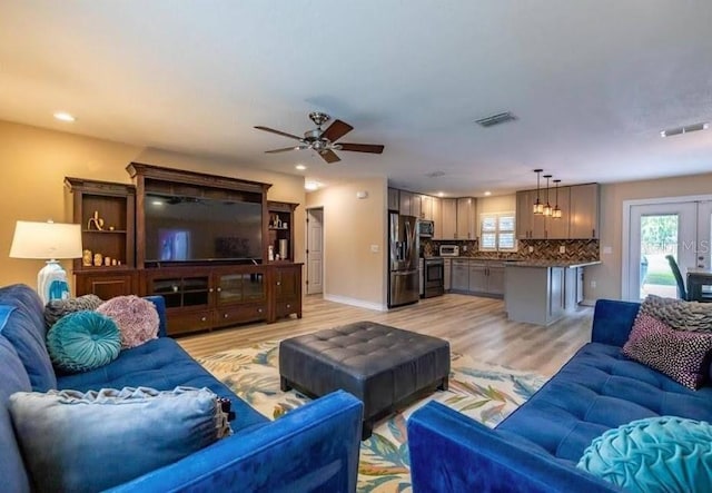 living room featuring light hardwood / wood-style floors and ceiling fan