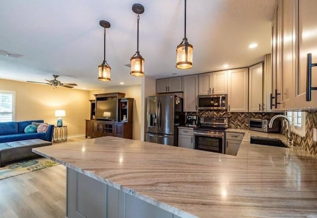 kitchen featuring sink, kitchen peninsula, and appliances with stainless steel finishes