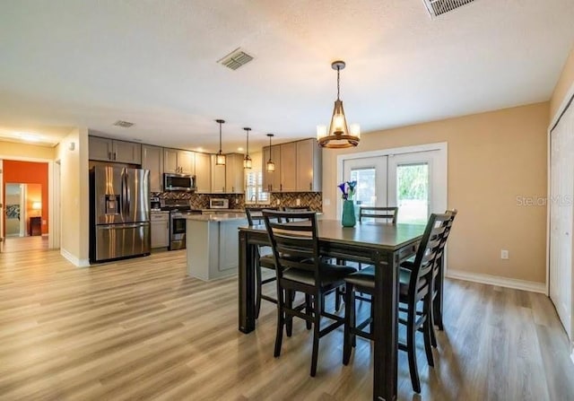dining space featuring french doors and light hardwood / wood-style floors