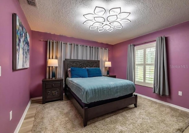 bedroom with hardwood / wood-style flooring and a textured ceiling