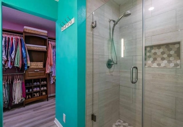 bathroom featuring a shower with door and hardwood / wood-style floors