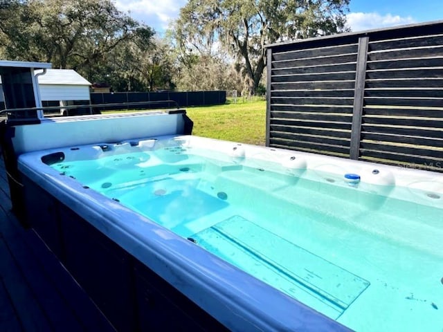 view of swimming pool with a hot tub and a lawn