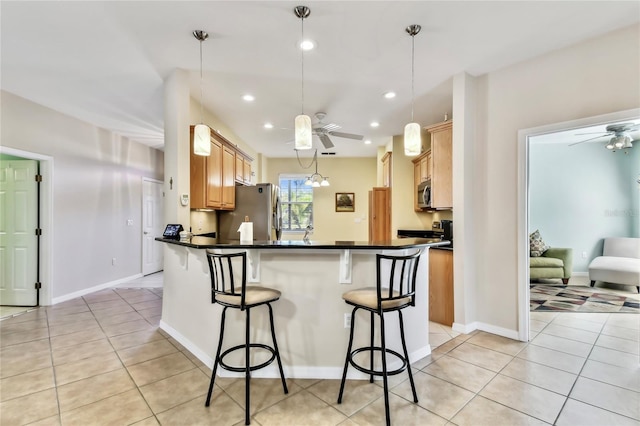 kitchen featuring hanging light fixtures, stainless steel appliances, kitchen peninsula, and ceiling fan