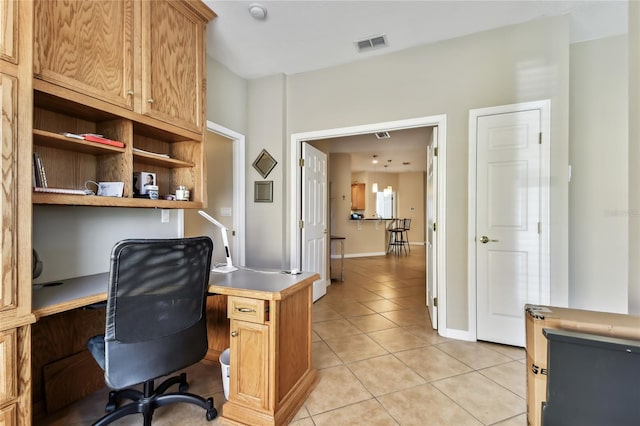 office area with built in desk and light tile patterned flooring