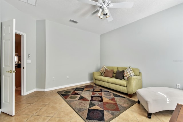 tiled living room with a textured ceiling and ceiling fan