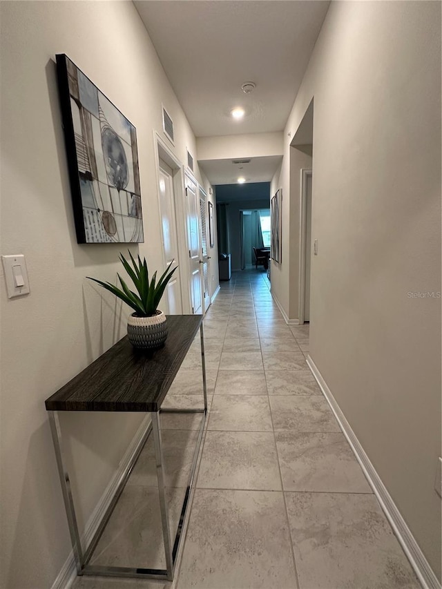 hallway featuring visible vents and baseboards