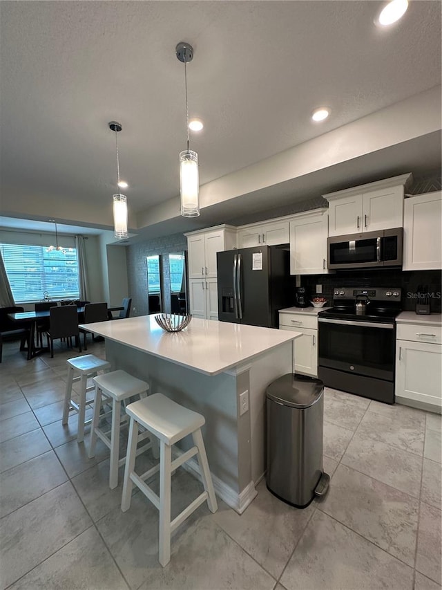 kitchen with black appliances, white cabinetry, and light countertops