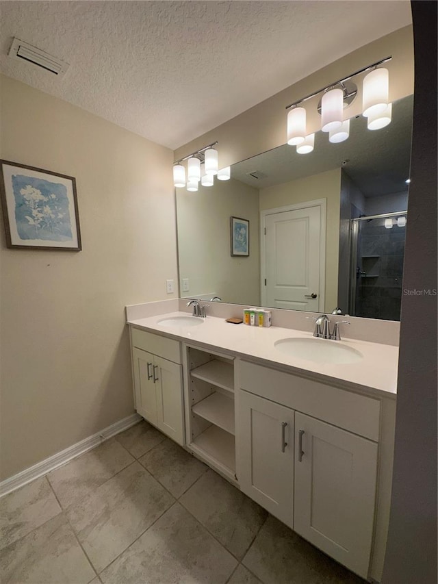 bathroom featuring visible vents, a sink, a textured ceiling, and double vanity