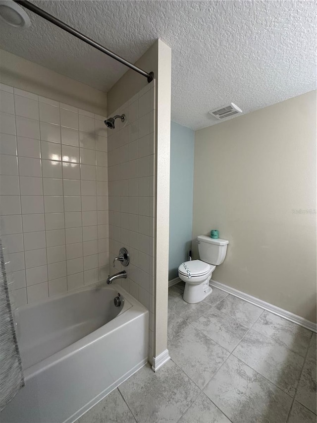 bathroom with a textured ceiling, shower / washtub combination, toilet, and baseboards