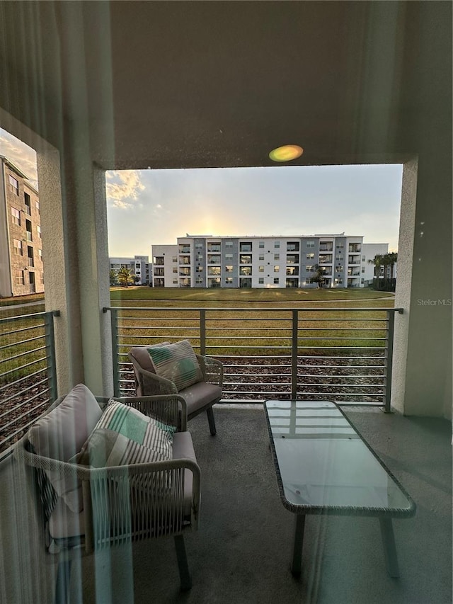 balcony at dusk featuring a city view