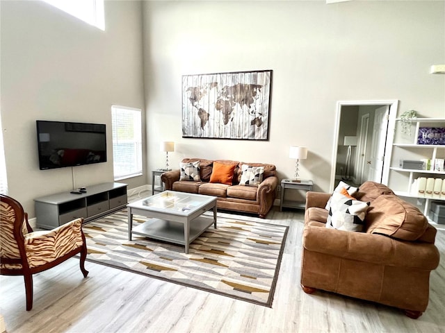 living room featuring light hardwood / wood-style flooring and a high ceiling