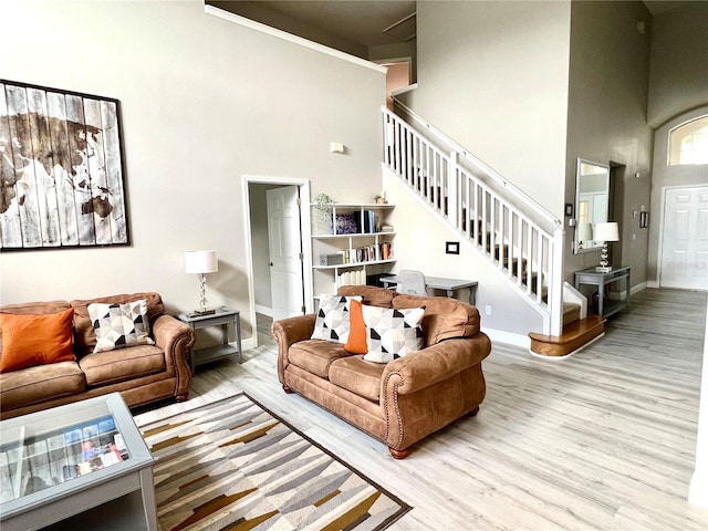 living room with a towering ceiling and light hardwood / wood-style floors