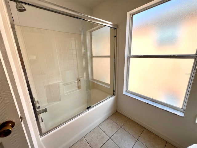 bathroom with a healthy amount of sunlight, bath / shower combo with glass door, and tile patterned flooring