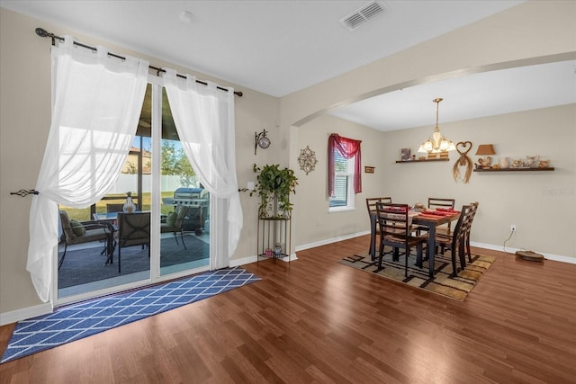 dining space featuring a notable chandelier, dark hardwood / wood-style flooring, and a wealth of natural light