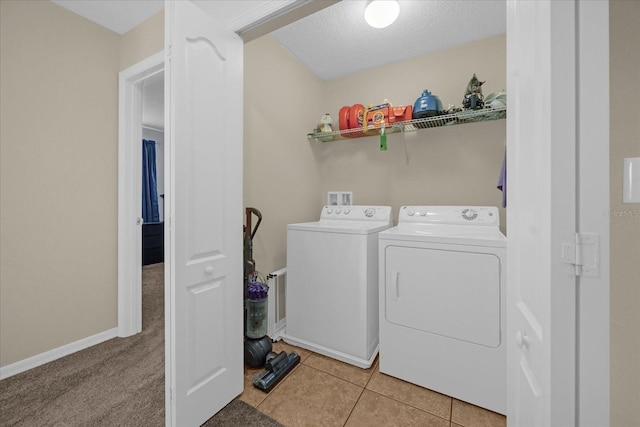 laundry area with separate washer and dryer, a textured ceiling, and light tile patterned floors