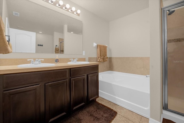 bathroom featuring vanity, plus walk in shower, and tile patterned flooring