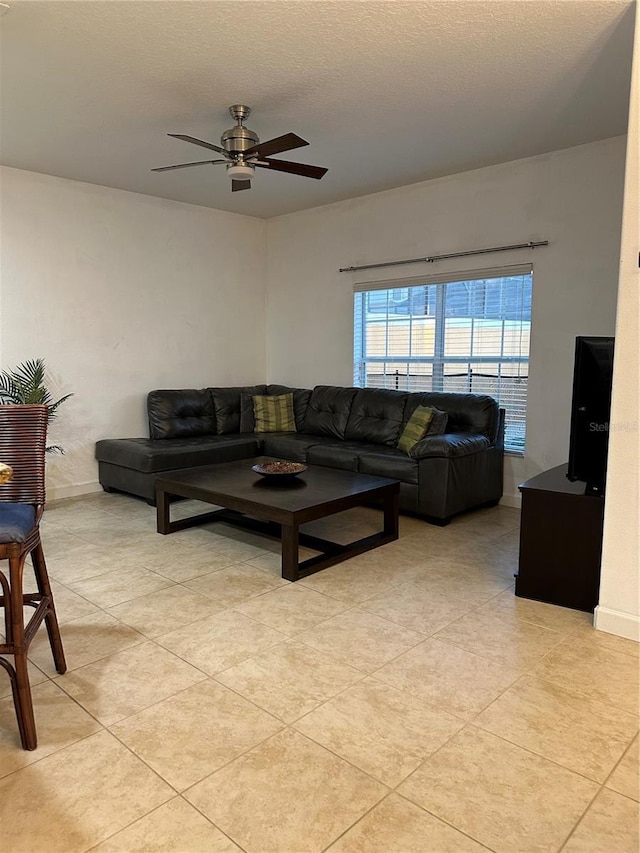 living room with light tile patterned floors, a textured ceiling, and ceiling fan