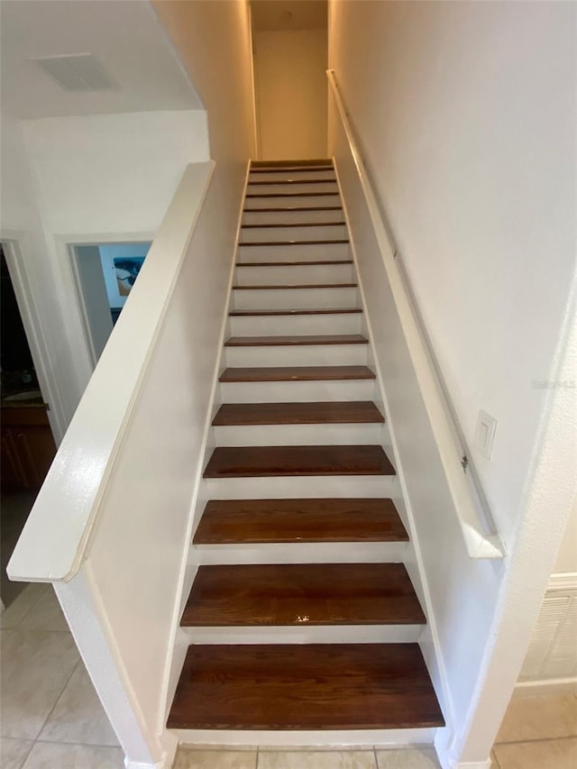 stairs featuring tile patterned flooring