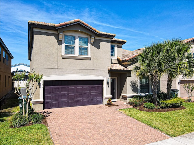 mediterranean / spanish-style house featuring a garage and a front yard