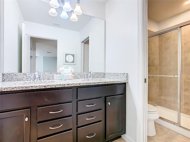 bathroom with toilet, an enclosed shower, vanity, a notable chandelier, and tile patterned flooring