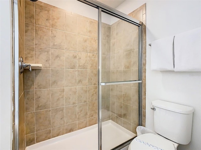 bathroom with toilet and an enclosed shower