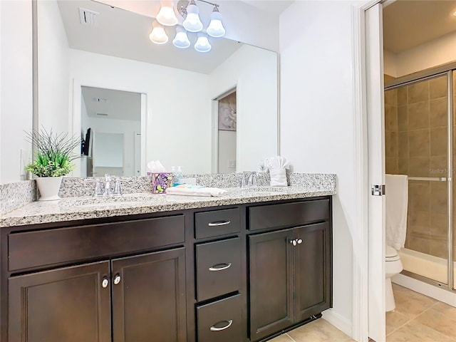 bathroom featuring tile patterned flooring, vanity, a shower with door, and toilet